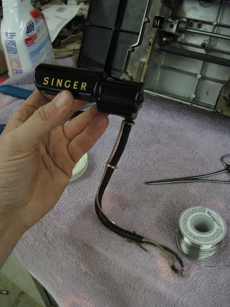 The lampholder with its new wiring. The new wiring is attached to a lenght of copper wiring which has three cleats soldered to it.